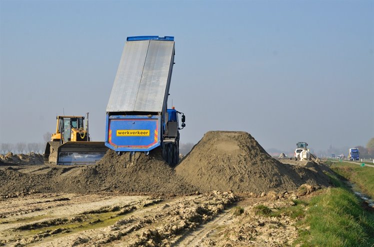 Vrachtwagen lost aarde op een werkterrein